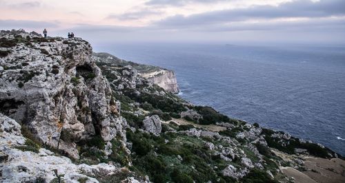 Rock formations by sea against sky