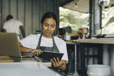 Female owner working on digital tablet in food truck