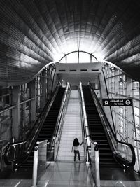 Rear view of people walking on escalator