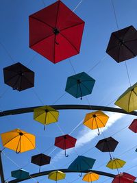 Low angle view of umbrellas hanging against sky