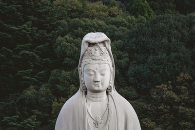 White statue against trees