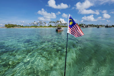 Flag on sea against sky
