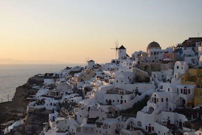 High angle view of townscape by sea against sky during sunset