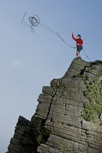 Woman throwing rope at windgather rocks in the british peak district
