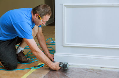 Man drilling on wall at home