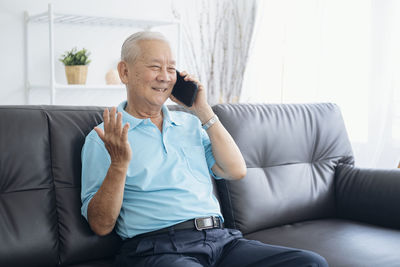 Full length of man sitting on sofa