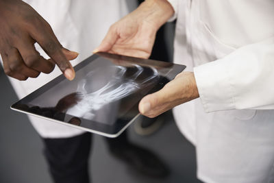 Doctor with colleague holding tablet pc with x-ray image at hospital