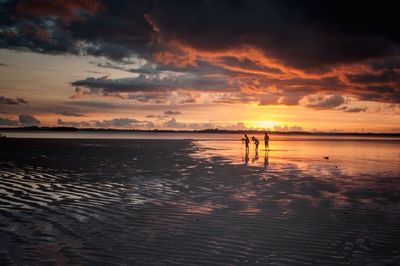 Scenic view of sea against cloudy sky at sunset