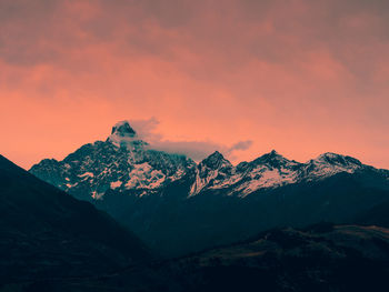 Scenic view of snowcapped mountains against sky during sunset
