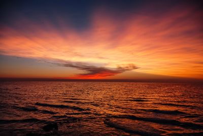 Scenic view of sea against dramatic sky during sunset