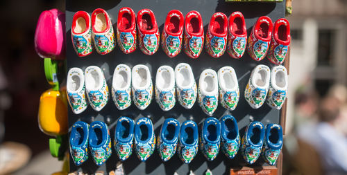 Close-up of clogs shoes hanging on board for sale at street market