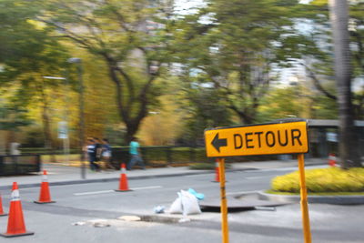Road sign against trees