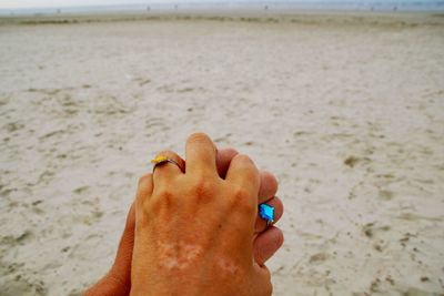 Midsection of person hand on sand at beach