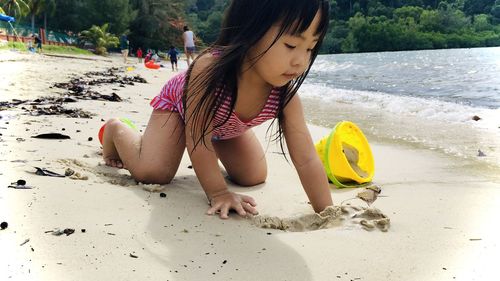 Girl playing with toy on beach