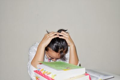 High angle portrait of woman on book against wall