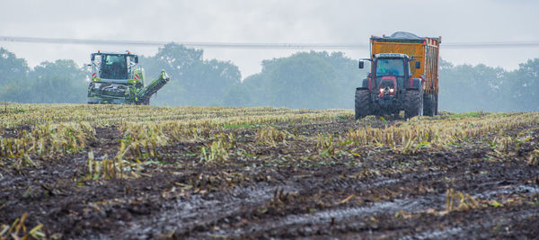 Agricultural machinery on field against sky