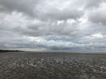 Scenic view of land against cloudy sky