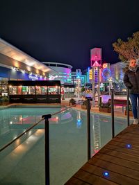 People standing in illuminated city at night