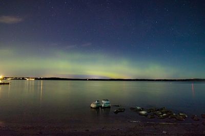 Scenic view of lake against sky at night