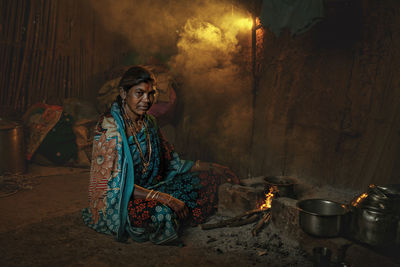 Young woman sitting on barbecue grill