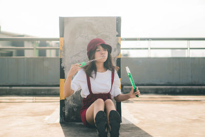 Full length of woman sitting outdoors