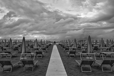 View of empty chairs against cloudy sky