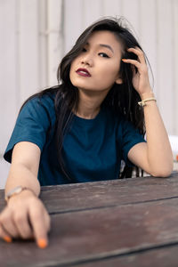 Portrait of young woman sitting on picnic table