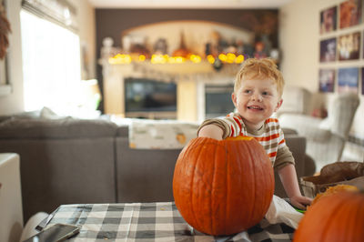 Toddler boy 3-4 years old scoops out pumpkin seeds with his hand
