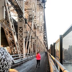 Rear view of woman standing on bridge