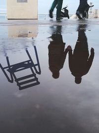 Low section of people with reflection on water