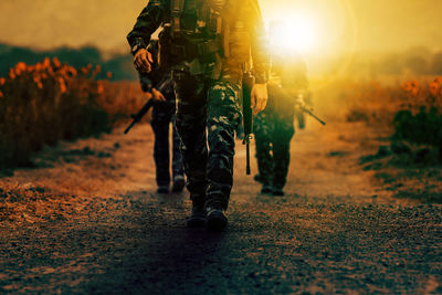 Low section of man standing on street during sunset