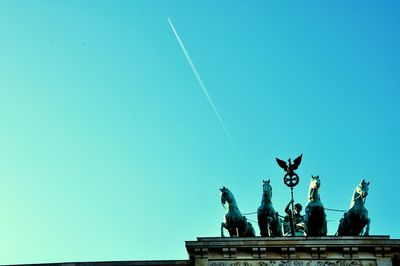 Low angle view of statue against clear blue sky