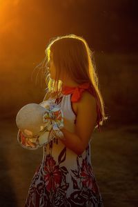 Woman holding girl standing outdoors