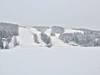 Snow covered landscape against clear sky