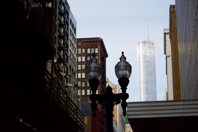 Low angle view of antique street light amidst buildings in city