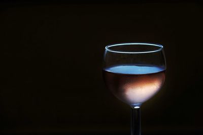 Close-up of wineglass against black background