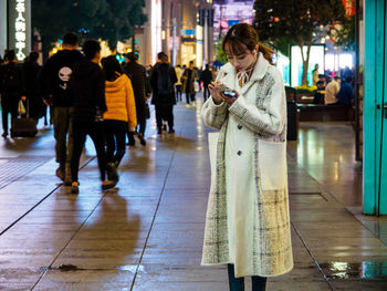 Woman walking on street in city at night