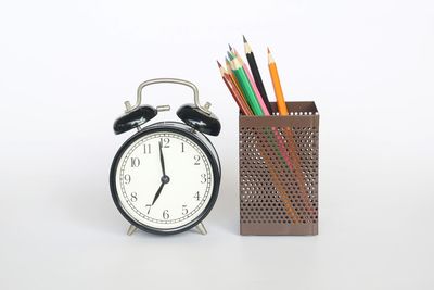 Close-up of clock on table against white background