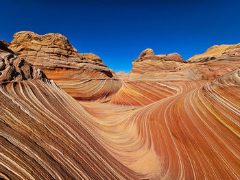 Scenic view of desert against clear blue sky