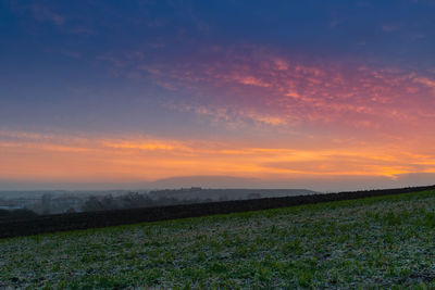 Scenic view of field against sky during sunset