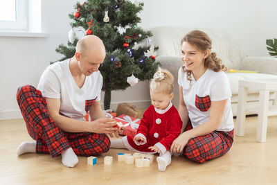 Portrait of siblings sitting on sofa at home