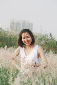 Smiling young woman standing on field