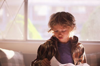 Boy reading paper at home