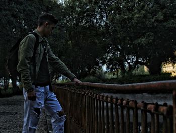 Side view of young man standing on footbridge