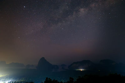 Scenic view of silhouette mountains against sky at night