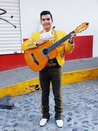 Full length portrait of man holding guitar