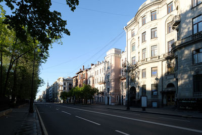 City street by buildings against clear sky