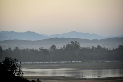 Scenic view of lake against sky during foggy weather