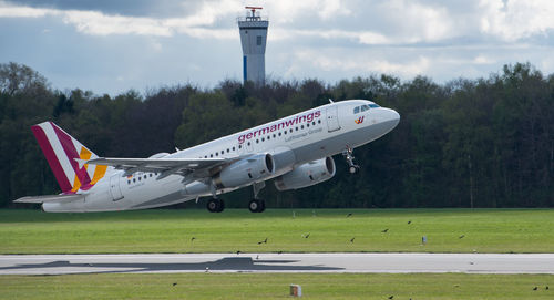 Airplane on airport runway against sky