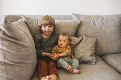 Sibling sitting on sofa